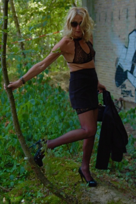 Kyras Nyros models her mid-pregnant look with a black skirt and stiletto heels, covered in hosiery.