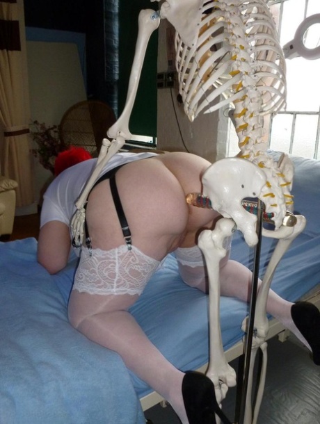 Valgasmic Exposed, an older redhead nurse, is struck by a dildo that has a skeleton attached to it.