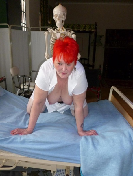Old redhead nurse Valgasmic Exposed is flung over by an animatronics-wielding, inflatable (skeleton) dildo.