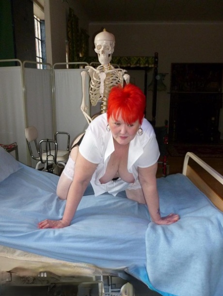 Valgasmic Exposed, a mature redhead nurse, is assaulted by an animatronics-wielding dildo.