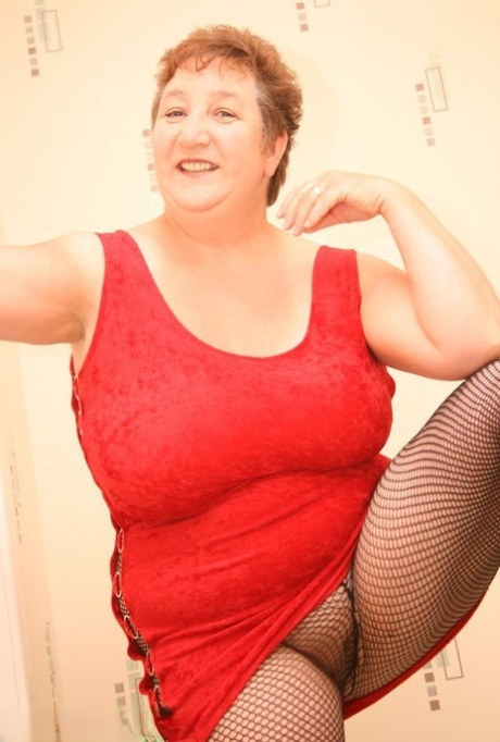 The older BBW Kinky Carol has short red hair and is naked with her natural tits.