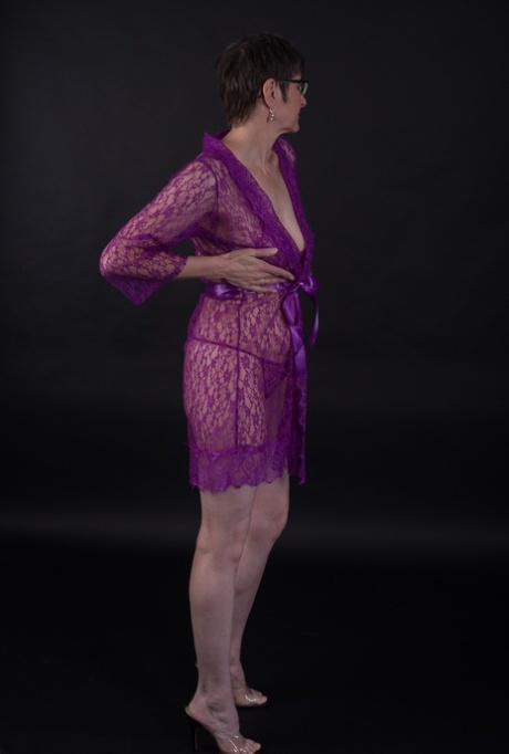 In purple lingerie, an elderly model models short hair while sporting it as a sport.