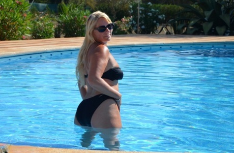 Sweet Susi, who is middle-aged and blonde, bares her breasts in a pool with a swimsuit.