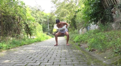 Chloe Lamour, a distressed girl, is seen peeing on a cobblestone path.