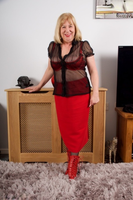Red skirt and satin panties are worn by Speedy Bee, a mature British woman, as she slips off.