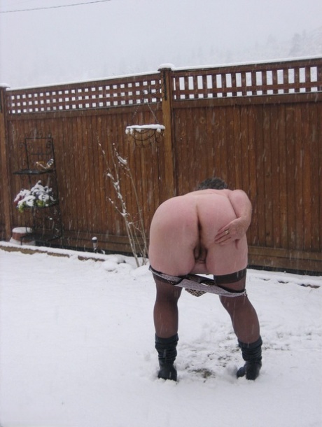 The Naughty Granny Girdle Goddess bares her stockings and boots while it snows.