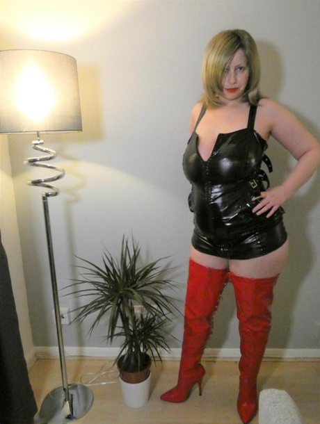 Older amateur Posh Sophia loosens her latex clothing with her booties while wearing them.