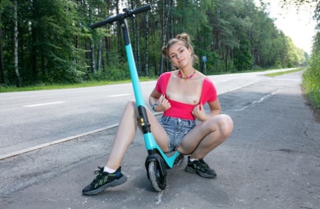 A cute girl named Lisa takes her scooter to a park and emerges naked in sneakers.