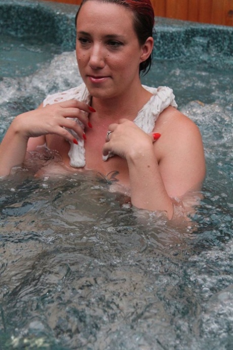 Free from clothing and other objects, Sara Banks, a young woman with ample height, takes her first steps in an outdoor hot tub.