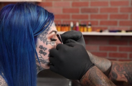 Сильно татуированная девушка Эмбер Люк позирует обнаженной в тату-салоне.