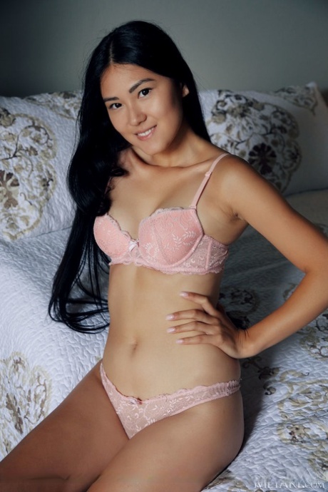 In a nude pose on her bed, Asian Kimiko removes a bra and thong set.