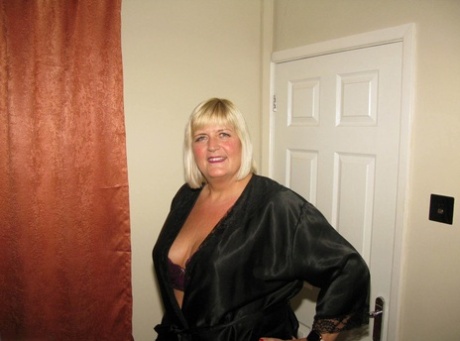 BBW Chrissy Uk models wearing pantyhose and lingerie on an leather loveseat with blonde hair.