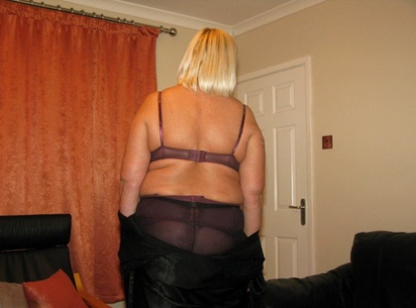 An older blonde BBW Chrissy Uk models their lingerie and pantyhose on a leather loveseat with her.