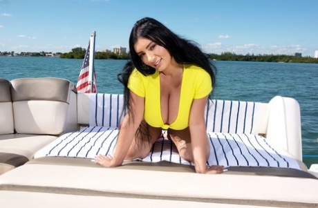 Black Latina Selena Adams, with dark hair, shows off her large breasts on a boat.