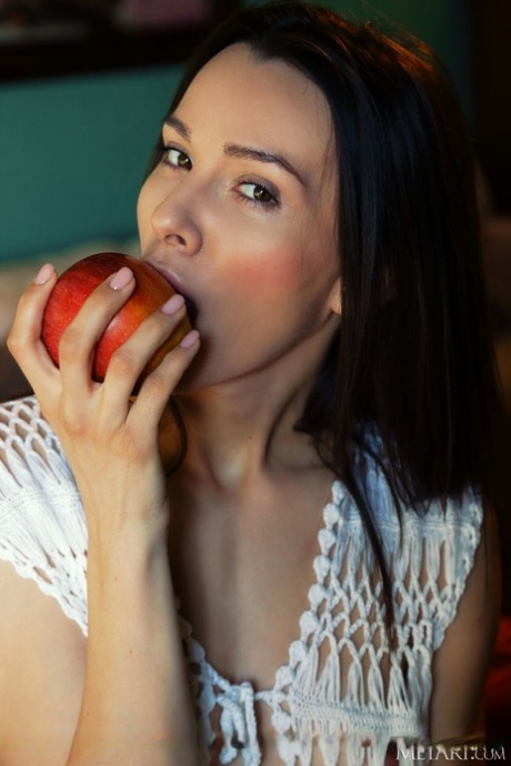 Long legged teen Adel Morel bites into an apple before modelling in the nude