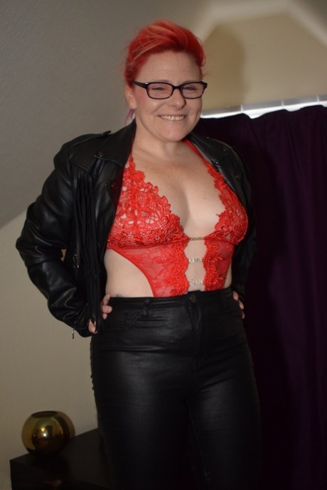 With a pair of leather pants and a thong, Mollie Foxxx, the thick redhead on her feet, releases her bald twat from the leather.