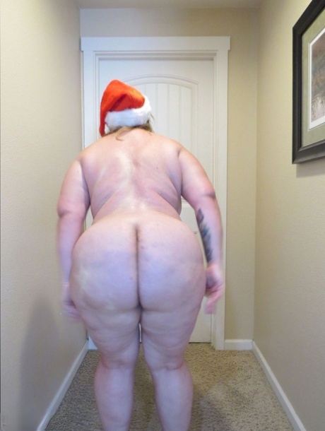Kristy, a fat woman, is seen in a photo with her self-made booty, including a Christmas hat and high heels.