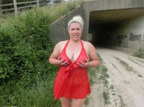 A rural scene features Barby, a blonde amateur, exposing her plump figure to the public.