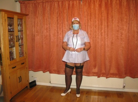Fat nurse Chrissy Uk removes a surgical mask and uniform to model lingerie