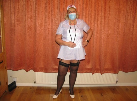 A surgical mask and uniform are removed by fat nurse Chrissy Uk as she models lingerie.