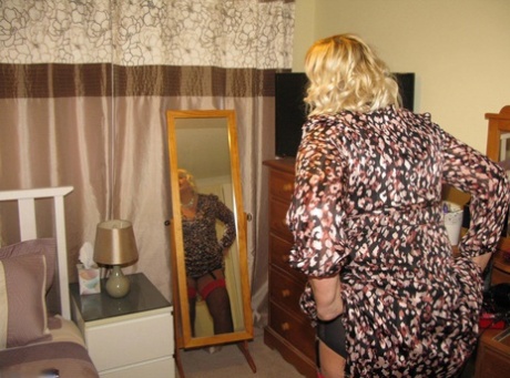 Chrissy Uk, the older and fatty blonde woman in her bedroom, places her labia lips on a chair.