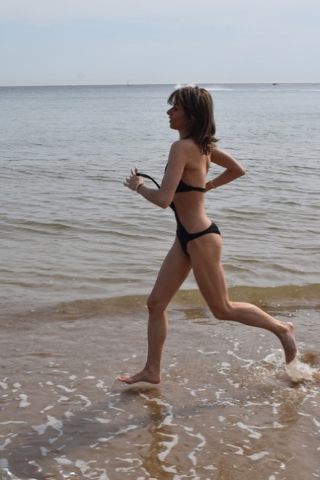 On a deserted beach, thin women pose in a bathing suit.