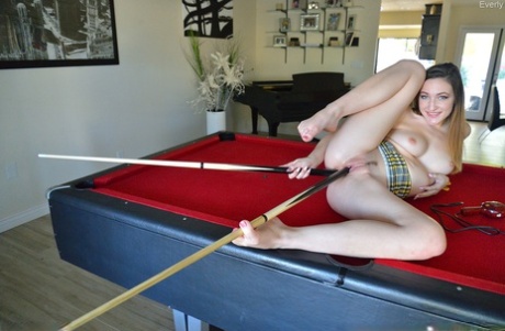 A girl who is not well-known inserts a few pool cues into her vagina on a table at a pool table.