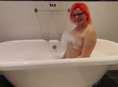 With her glasses on, Mollie Foxxx, a tattooed amateur, enjoys a bubble bath.