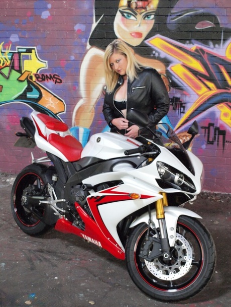 Blonde Samantha is seen wearing over the knee boots on a motorcycle while being fully clothed in her darkest figure.