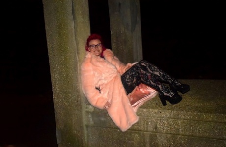 Despite her red-headed amateur status, Mollie Foxxx still flashes at night in a long coat.