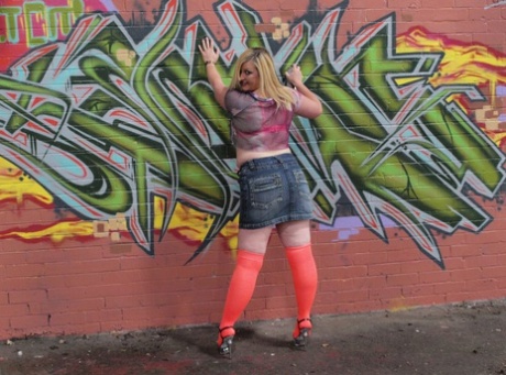 Striking: An amateur plumper named Samantha strips to knee-high nylons in front of graffiti.