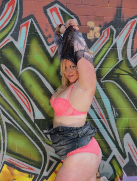 Amanda is an amateur plumper who wears knee-high nylon pants in front of graffiti.