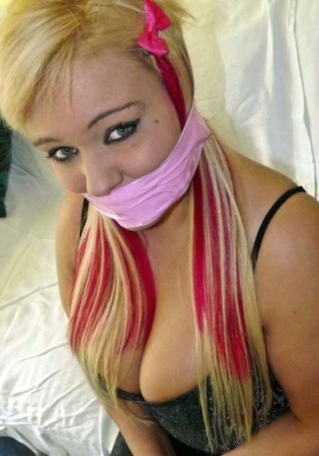 Blonde fatty skin is bandaged with her wrists and ankles tied down.