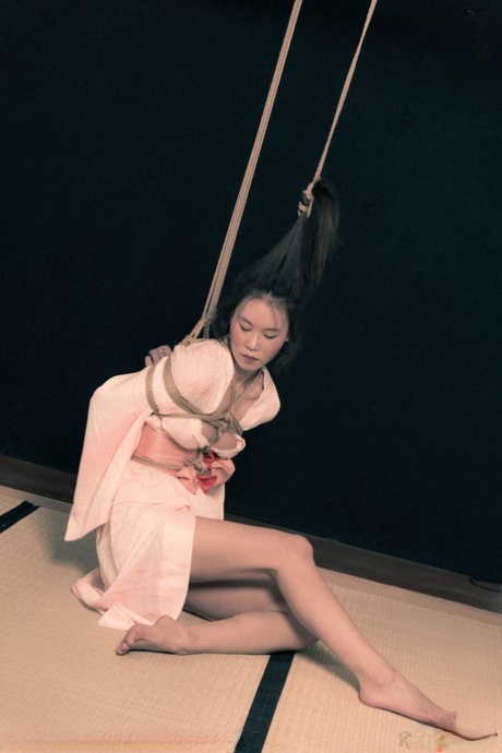 An Asian woman called Flawless Meow has her long hair and body tied up with rope.