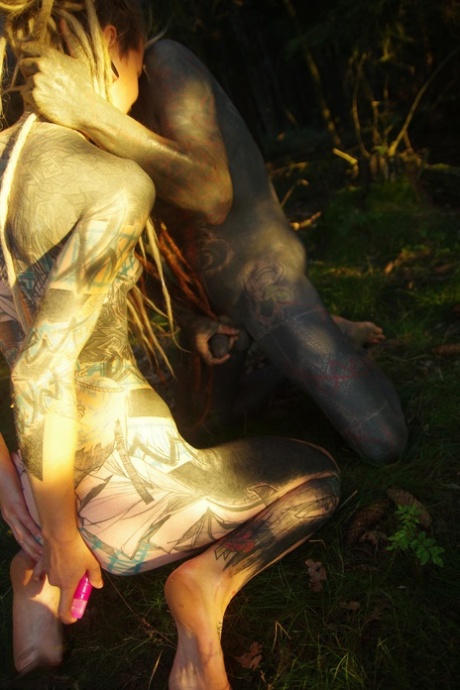Surreptitious acts: Tatted super heroes Anuskatzz & Lily Lu have sexual intercourse on the forest floor (left) and in a separate photo taken outside a tree house
