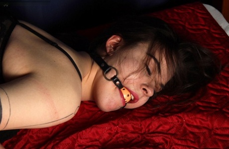 Ball gagged, the white girl's wrists are tied to her ankles in pretty fashion.