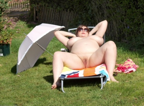 BBW Roxy, an amateur musician on a lawn chair, exposes himself in a pair of sunglasses while sitting on the chair.