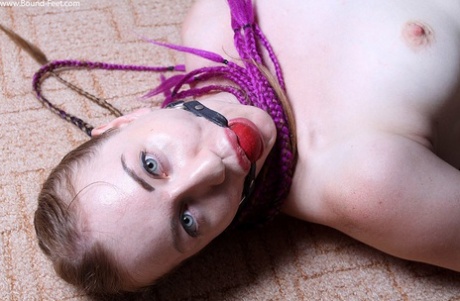 While being hogtied and ball gagged, the alternative girl experiences choking.