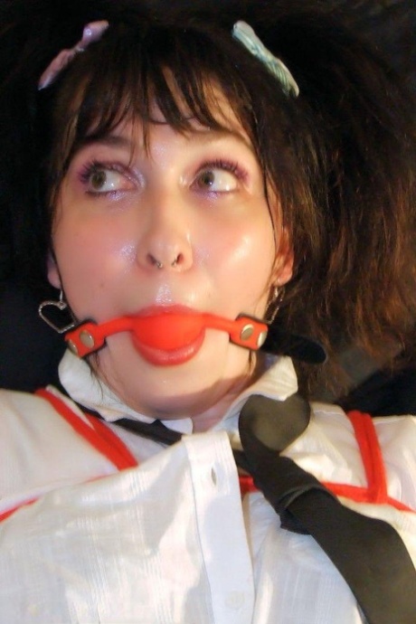 Ball gagged and tied up in uniform, the young student exposes her thong.