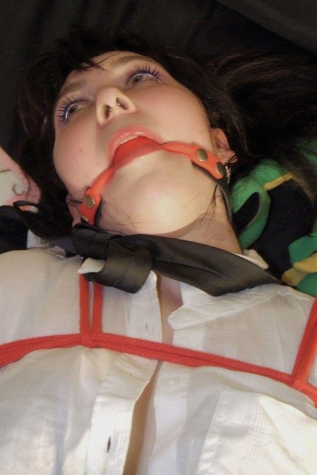 A student in their uniform exposes her thong while being ballgged and tied up in the outfit.