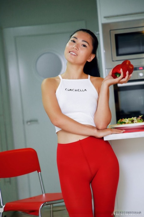 Asian teen Kimiko removes red tights to model completely naked in a kitchen