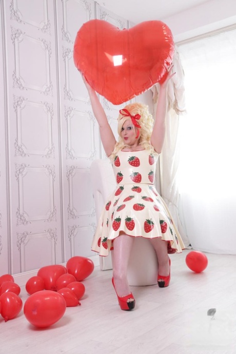 She wears hosiery and red heels: Thick blonde Avengelique models the latex dress with this image.