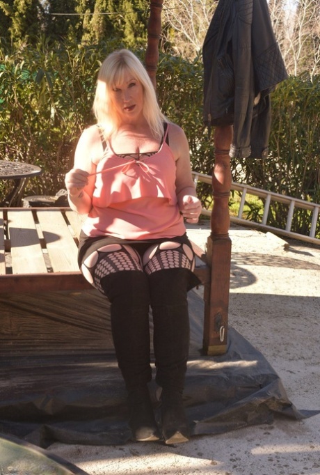 Overweight Blonde Melody Uncovers Her Brassiere On A Patio In OTK Boots