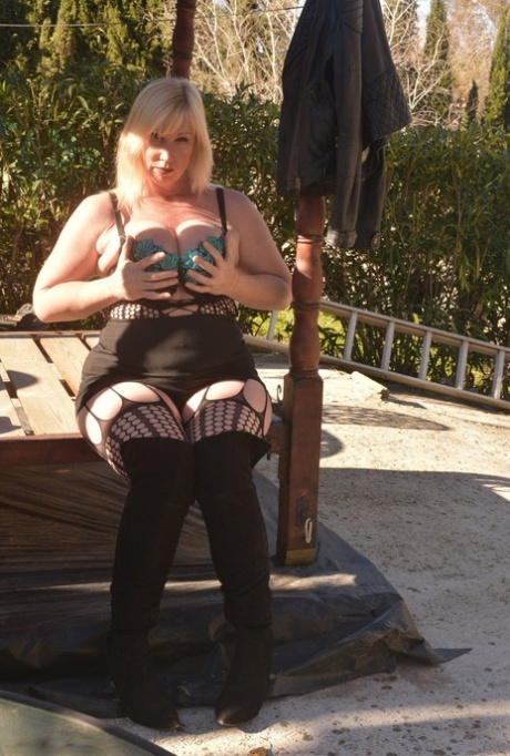 Overweight Blonde Melody Uncovers Her Brassiere On A Patio In OTK Boots