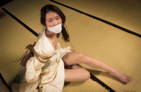 Flawless Meow, a Japanese woman, is subjected to gaffes during a Shibari presentation.