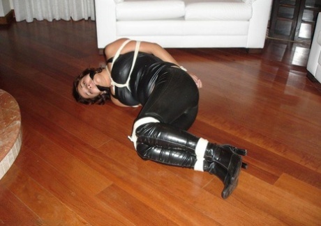 Boots are worn by a barefoot amateur who is tied up in leather clothing.