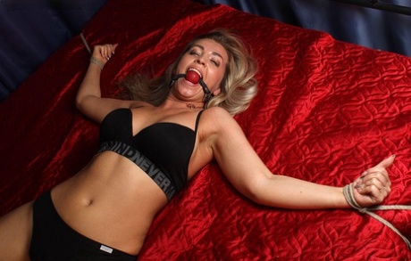 Dirty blonde sports a ball gag while tied to a bed in her underwear