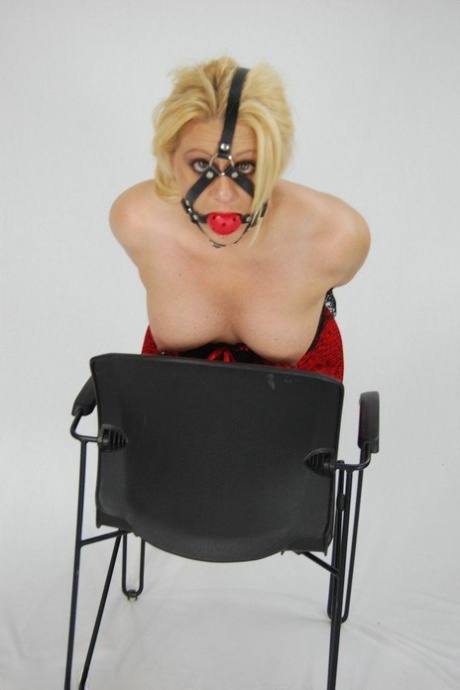 A hardy blonde is held in chains and subjected to a ball gag until the cock is fully developed.