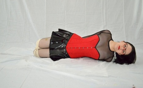 An unabashed girl finds herself hogtied in her latex miniskirt and glasses.