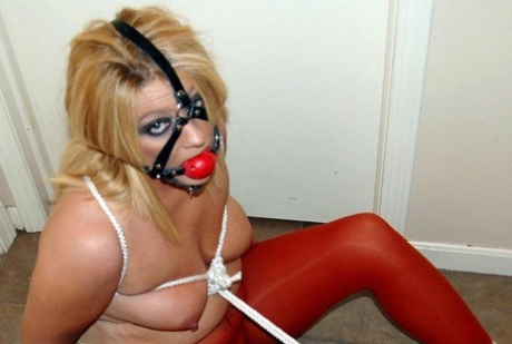 With her tits tied up with rope, Adrienna is seen wearing a thick blonde shirt and is ball bound in hoses.